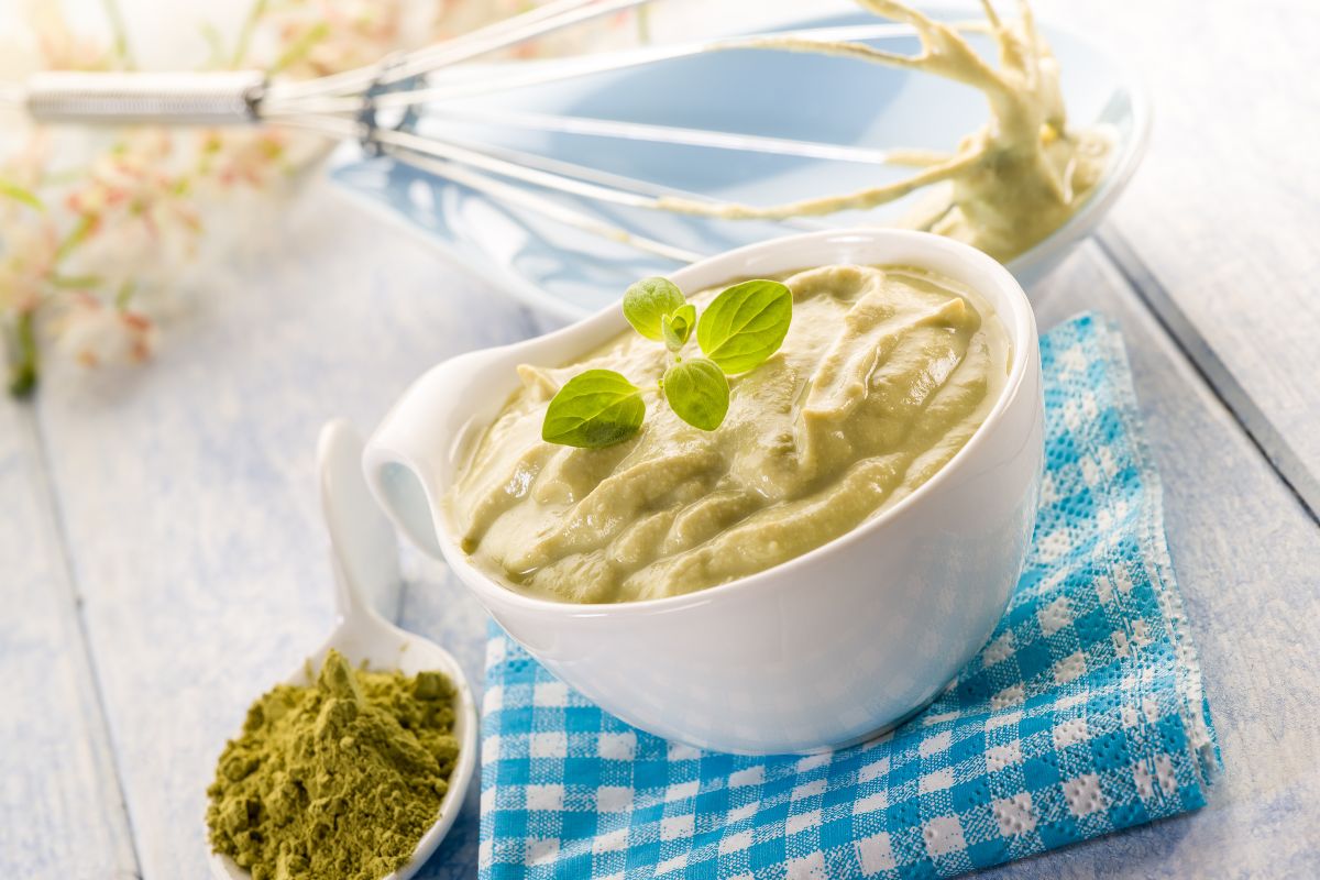 Mousse salata o paté cremoso verde in una ciotola con origano e polvere di spezie.
