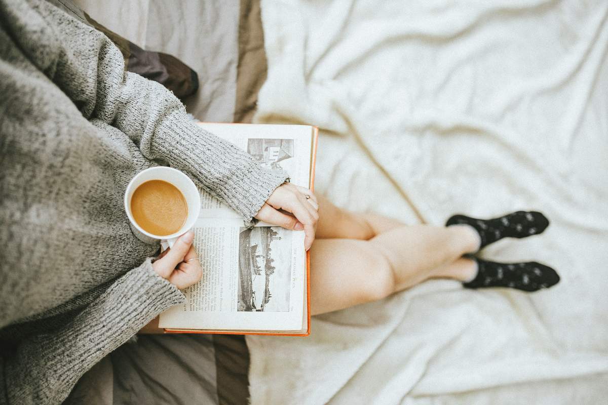 donna con libro e tazza di caffè