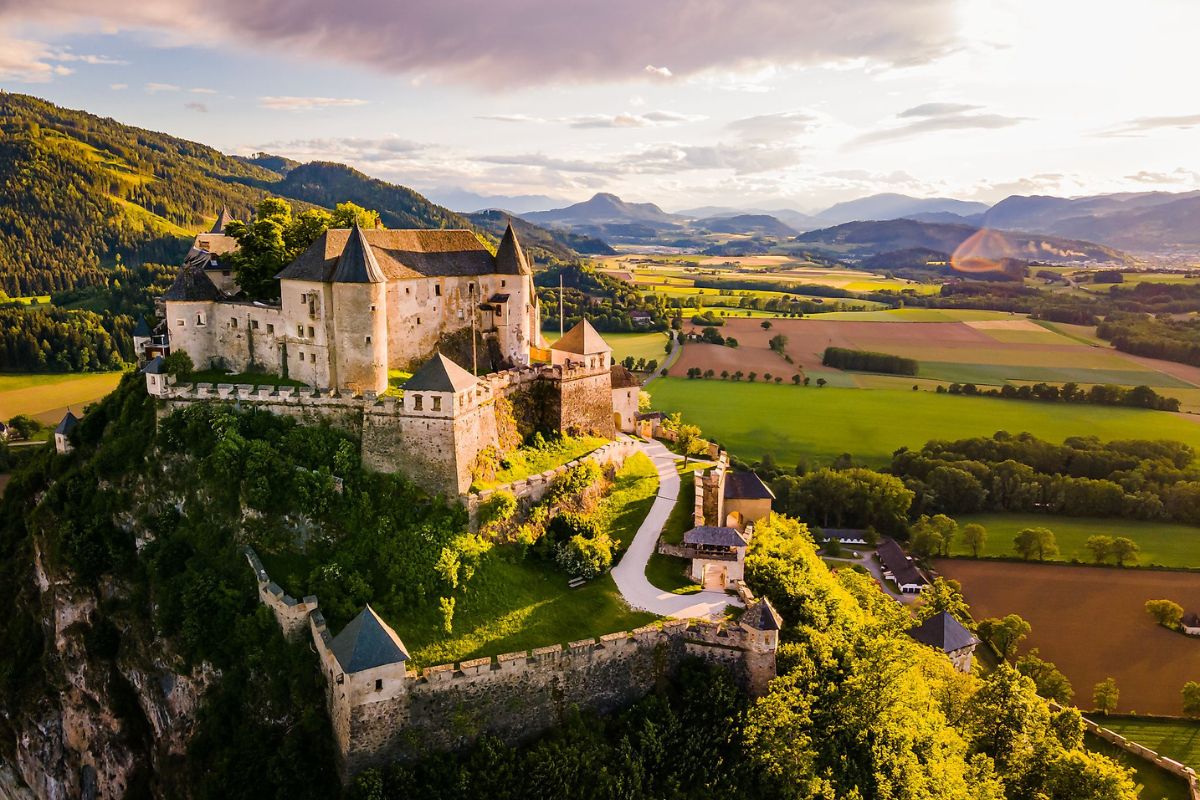 Veduta aerea del castello medievale di Hochosterwitz in Austria su una collina al tramonto.