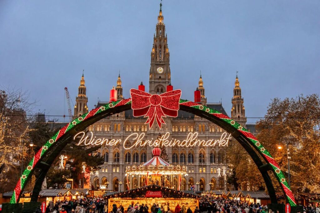 Mercatino di Natale Vienna Rathausplatz: ingresso illuminato Wiener Christkindlmarkt con Municipio neogotico sullo sfondo