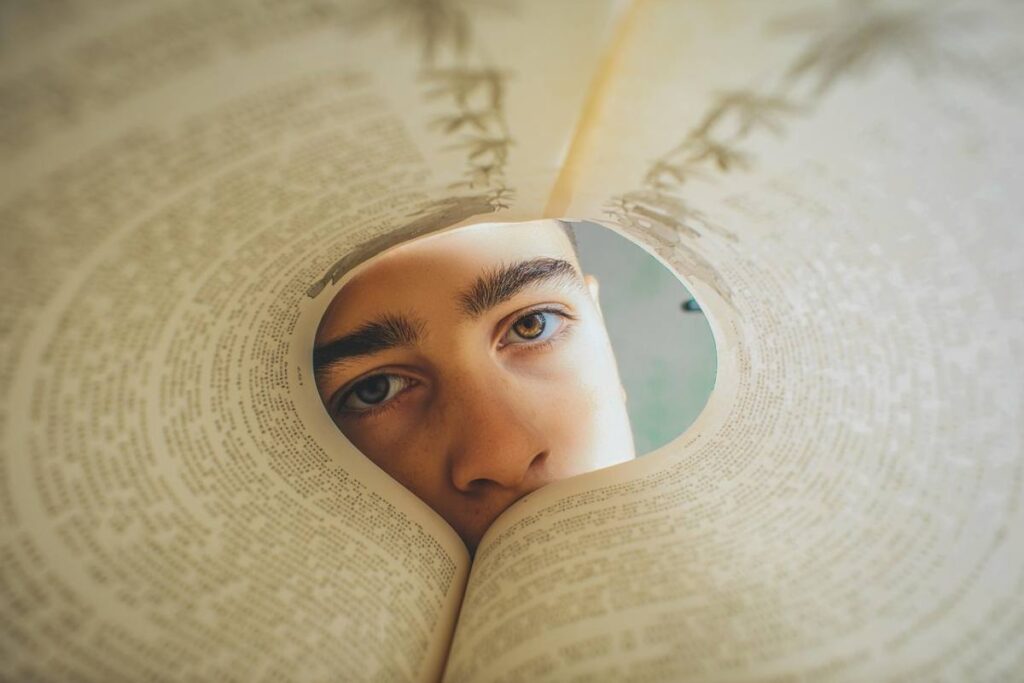 ragazzo con volto nascosto da libro