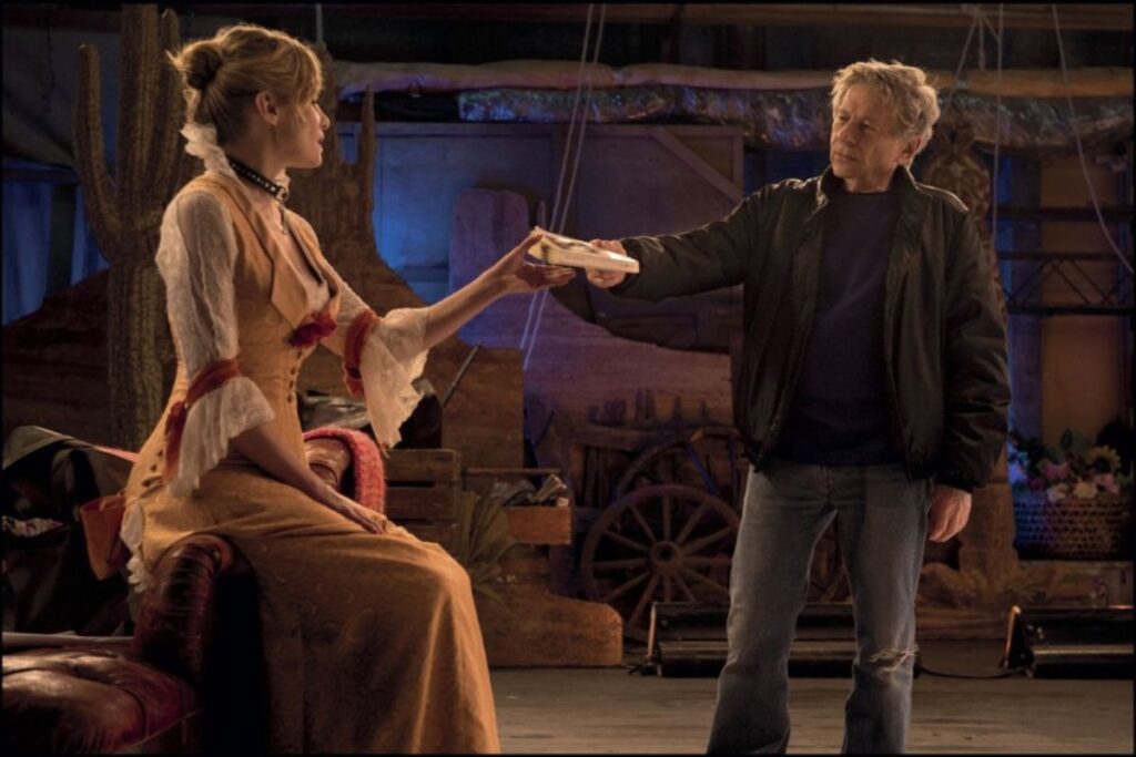 Scena dal film "Venere in pelliccia" di Polanski con un uomo e una donna in costume teatrale in un set.