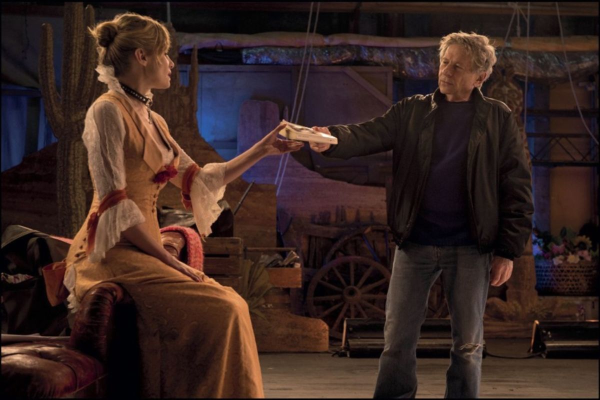 Scena dal film "Venere in pelliccia" di Polanski con un uomo e una donna in costume teatrale in un set.